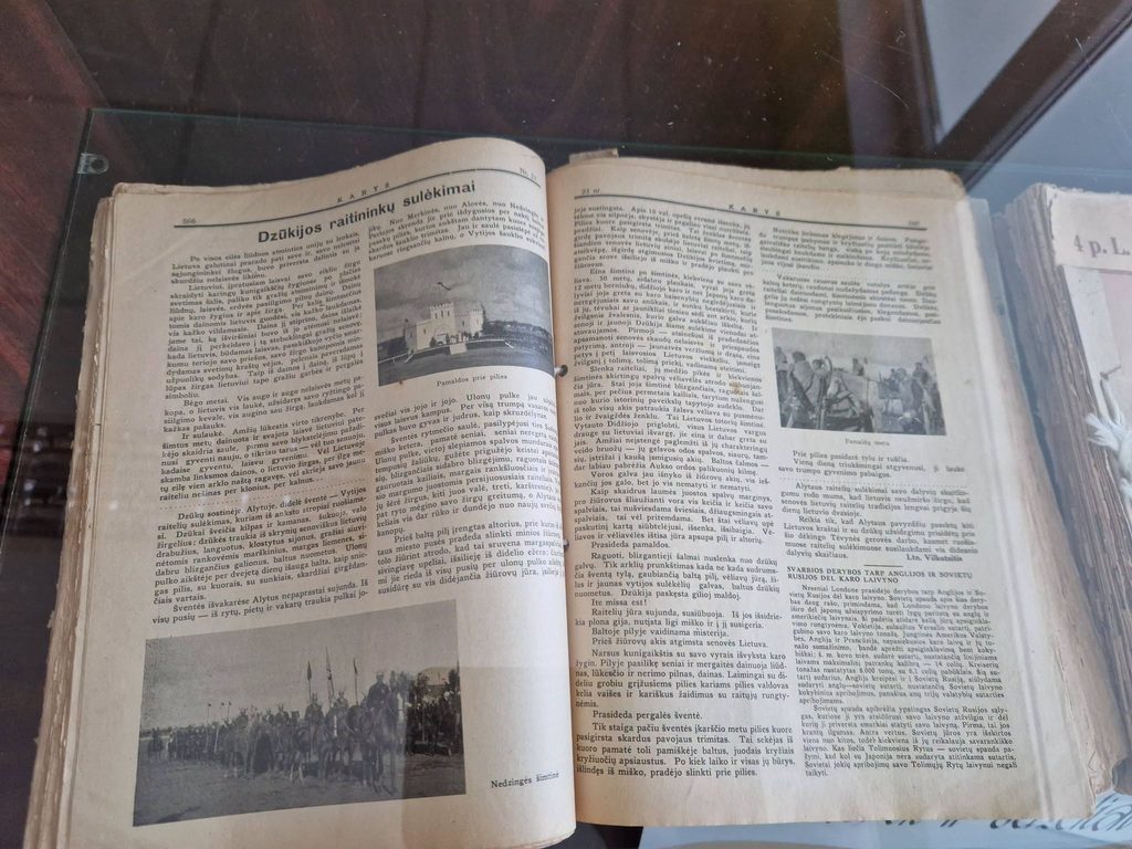 Atverstas senas leidinys vitrinoje; matoma antraštė „Dzūkijos raitininkų sulėkimai“.