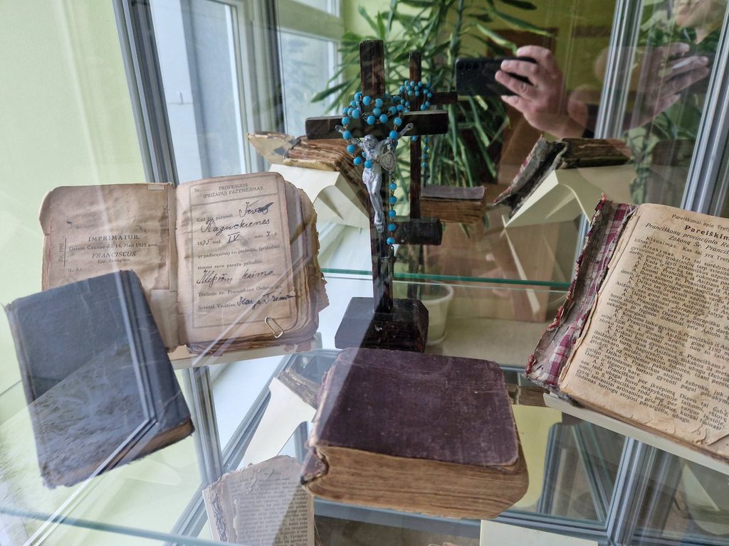 Parodos vitrinoje eksponuojamos senos maldaknygės, knygos, kryželis ir rožinis.